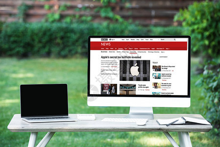 用空白屏幕计算机和户外餐桌边bbc新闻网站的空白屏幕电脑图片