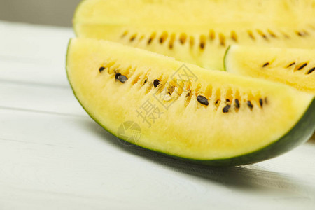 含白木板上种子的成熟黄色美味西瓜选择聚焦点图片