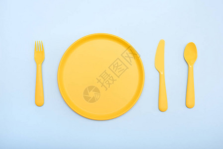 餐具黄色蓝色背景上的盘子刀子叉子图片