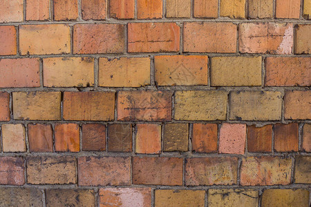旧墙由不同颜色的砖制成手工艺品手工制作品刮痕表面图片