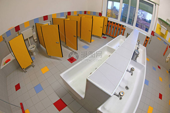 没有孩子的幼儿园公共浴室内部有小水槽和黄色门用图片