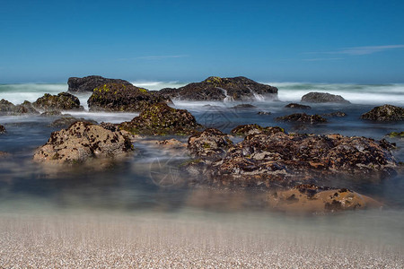 海浪拍打在北加州锯齿状海岸线上的岩石上图片
