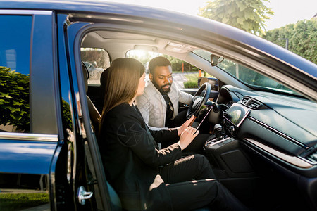 非裔美国青年男子在汽车驾驶期间与白人女同事沟通图片