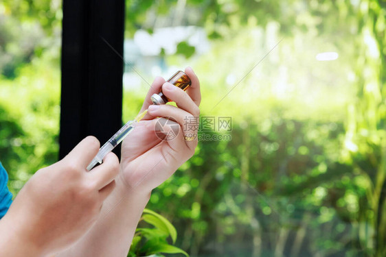 手持注射器和药瓶准备注射给病人进行流感保护药物治疗概念掌上型图片