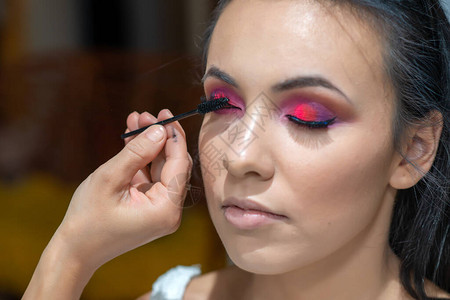 女人用化妆刷在眼睫毛上涂黑的玛斯卡拉图片