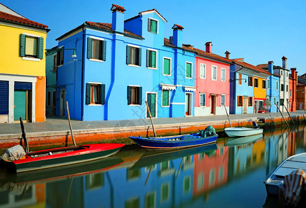 意大利威尼斯附近的布拉诺岛和对色彩缤纷的房屋通航水道的反射长时图片