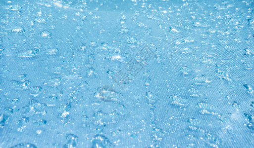 蓝色玻璃散景背上的雨滴图片