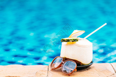 在酒店度假村的游泳池周围喝椰子果汁以图片
