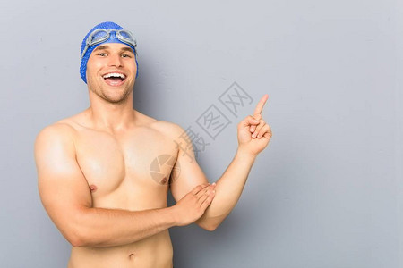 年轻的职业游泳运动员微笑地着与食图片