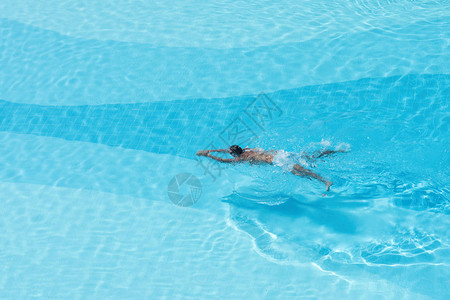 对游泳池里男孩的空中观察带有透明的蓝背景图片