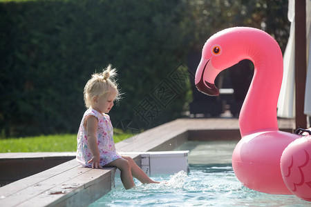 可爱的小孩女在游泳池玩得开心玩着粉红图片