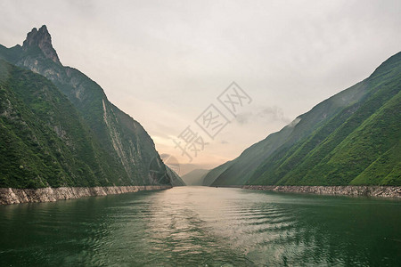 绿水以橙色光照天空进入绿林山和一些悬图片