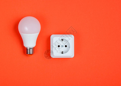 白色塑料电源插座和橙色背景的LED图片