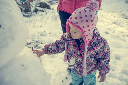 母亲和女儿在造雪人与家人图片
