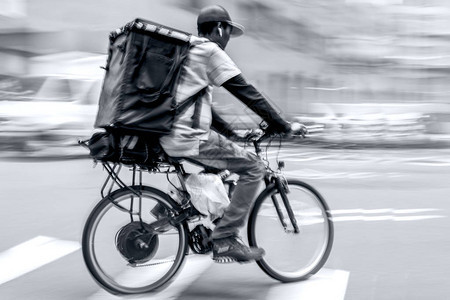 在城市公路运动上交通中的自行车交付时图片