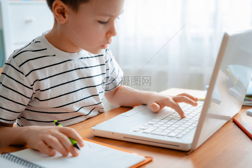 一个男生在家学习并做学校作业图片