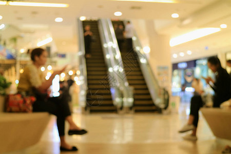 人们在购物中心大厅使用移动电话的情况模糊不清图片
