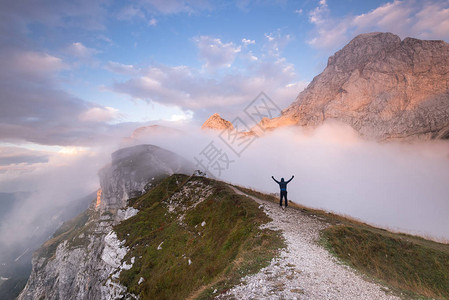 在山峰边缘站着的男子冒险和活跃的图片