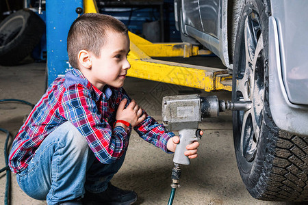 这个男孩梦想成为一个成年人并修理汽车图片