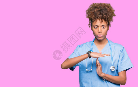 身处孤立背景的年轻非洲女医生用双手沮丧和严肃的面孔做时图片