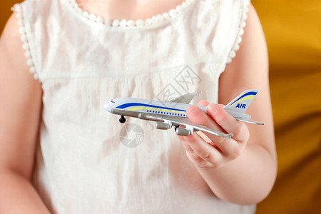 拿着玩具飞机假期和飞机安全概念的小女孩图片