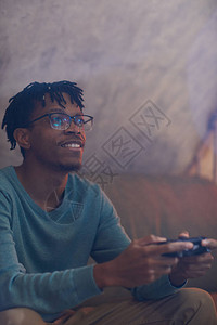 当代非裔美国人在玩电子游戏时持有游戏板控制器的肖像Play图片