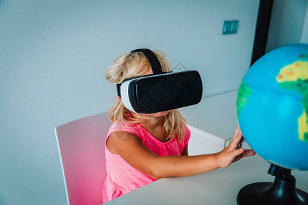 带虚拟现实谷歌的小女孩在家远程学习图片