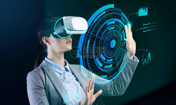 技术和业务现代女商人在VR眼镜按下钮在虚拟屏幕与未来的图表和图图片