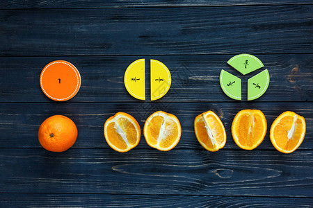 创意学习桌面五颜六色的数学分数和橙子作为深色木制背景或桌子上的样本有趣的创意有趣的数学为孩子们教育背景