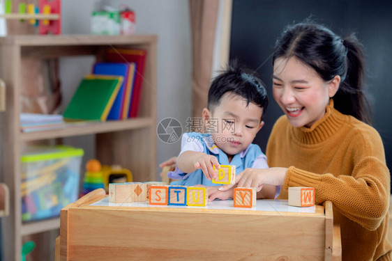 学前班的亚洲学生用信箱和老师在教室里做一个学习词图片