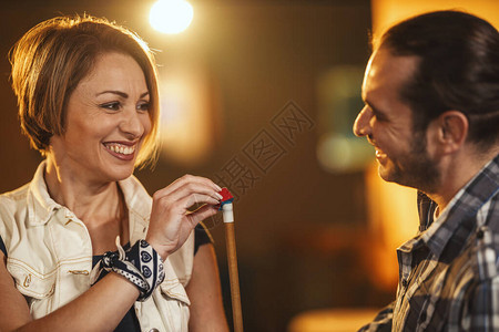 微笑的年轻女子在台球俱乐部中将粉图片