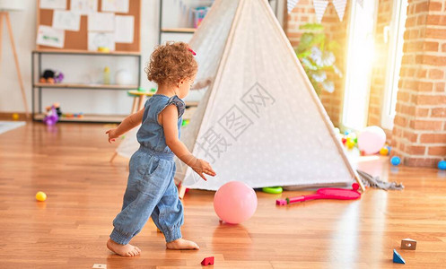 美丽的caucasian婴儿在丰富多彩的游戏室玩具在幼稚园和粉红一图片