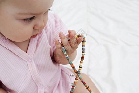 婴儿手中的有色珠子培养儿童的精细运图片