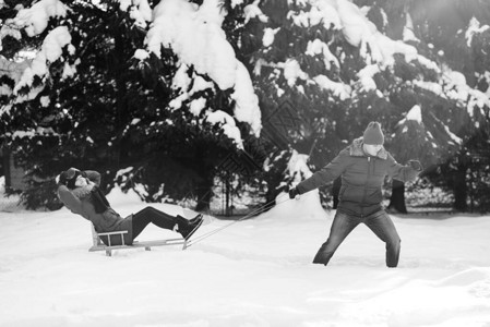 玩雪球和雪橇在冬季散步的户图片