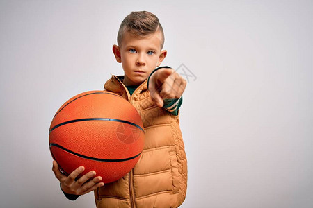 年轻的白种人运动小孩在孤立的背景上打篮球图片