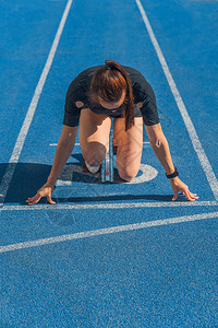 女运动员在开始跑步前按背景图片