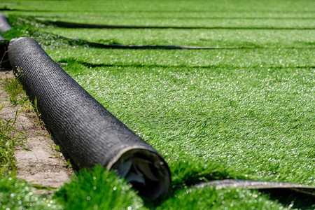 新体育场的草卷合成人造草皮开始覆盖体育场以踢足球图片
