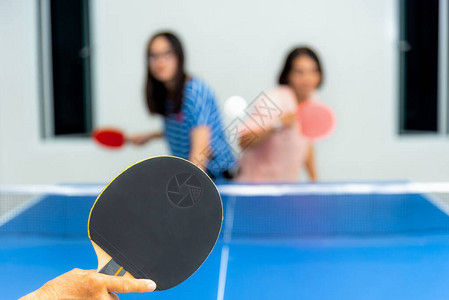 亚洲家庭在室内玩乒乓球或乒乓球图片