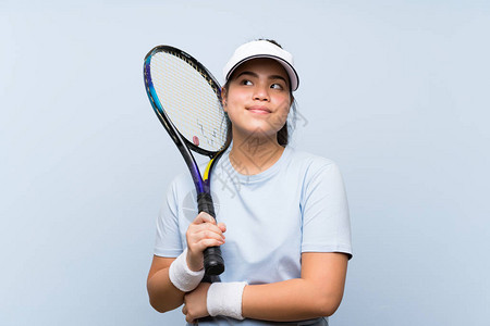 玩网球的亚洲少女在肩上举起肩膀时图片