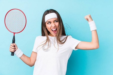 玩羽毛球的年轻文化女在胜利后独自举起拳头图片