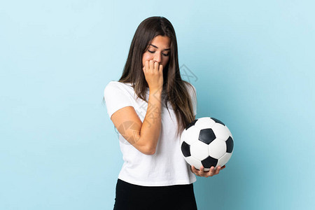 年轻足球运动员brazilian女孩被隔离在蓝背景图片