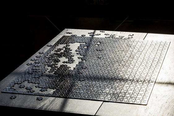 拼图游戏的片段桌子上的黑色拼图棋图片