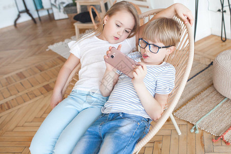 男孩和女孩在家看手机图片