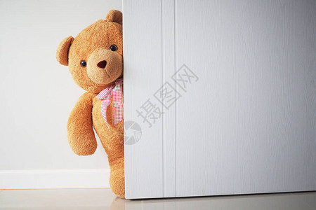 Teddy熊和棕色头发在门后打开孩子们玩Ted图片