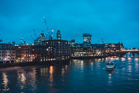 英国格兰伦敦环球之夜在泰晤士河上游船过去低隆水下海滨建筑和城市天空线CitySkyline建造图片