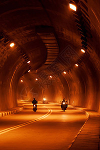 运动模糊亚洲人骑摩托车在黑暗的红图片