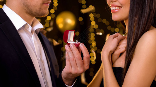 快乐的女看着钻石戒指男朋友求婚图片