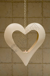 在一个心形的金属蜡烛架上烧着茶灯蜡烛挂图片
