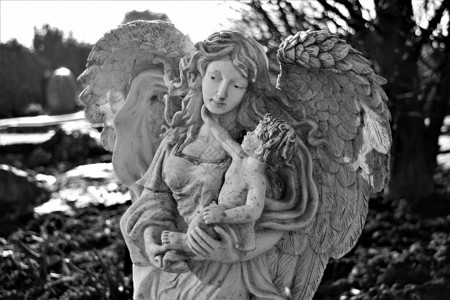 美丽的天使有大翅膀抱着孩背景图片