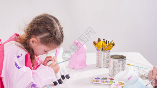 小女孩画纸木头雕像带有丙烯涂料的小姑娘在背景图片